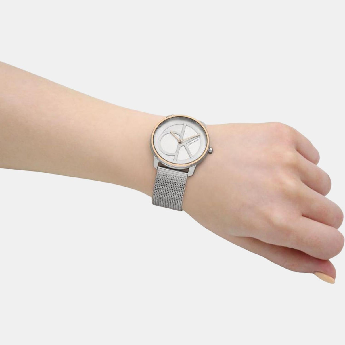 Unisex Calvin Klein Iconic watch worn on wrist with silver mesh bracelet