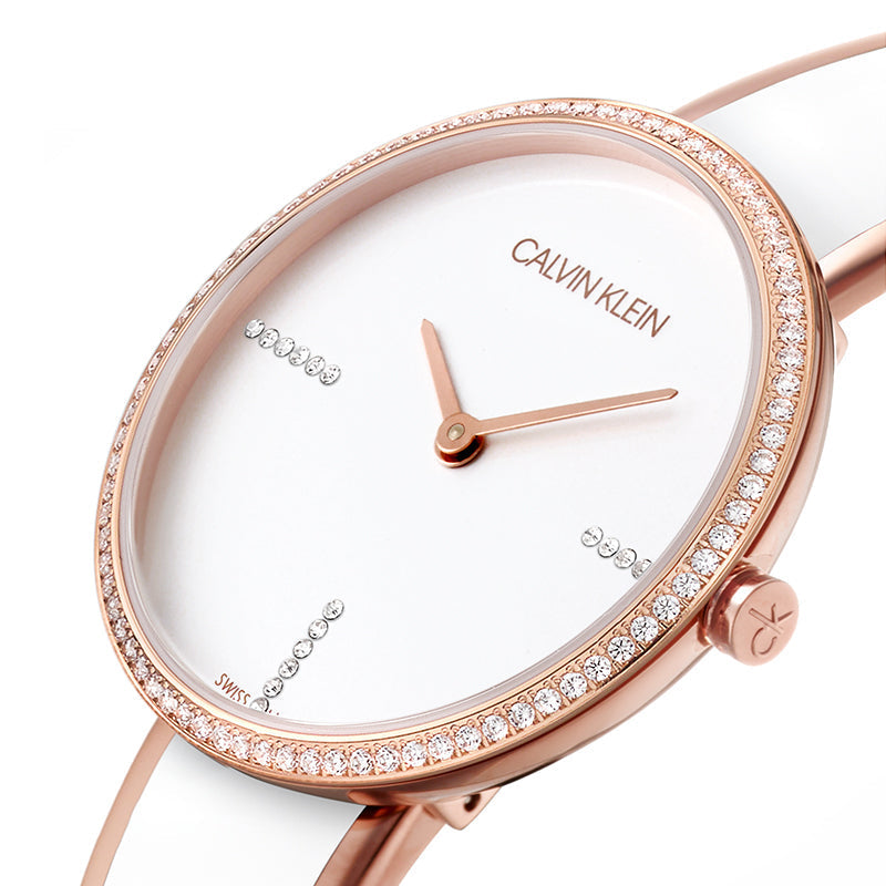Detailed view of white dial with crystal-set bezel, rose gold hands, and Calvin Klein logo