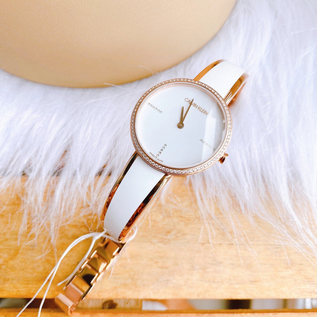 Calvin Klein Seduce watch worn on wrist, displaying elegant white dial with rose gold case and accents