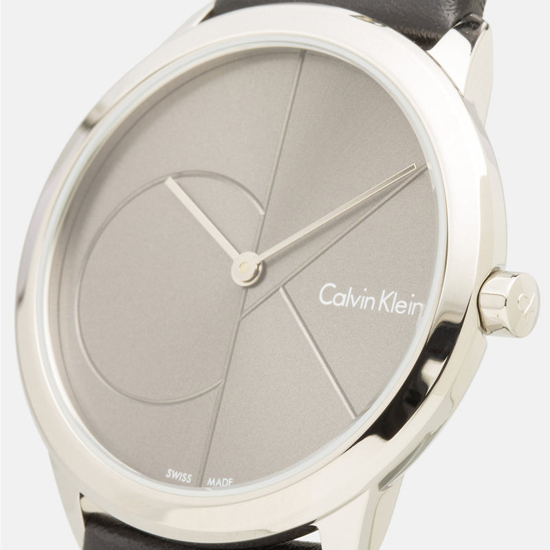 Angled view of grey dial with geometric design and black leather strap