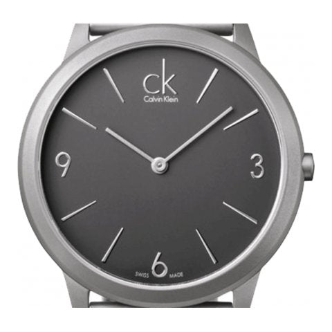 Calvin Klein Minimal K3M53154 dial close-up with grey face, numbered hour markers, and CK logo