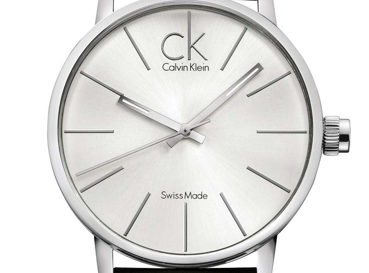 Close-up of silver dial with hour markers and Swiss-made movement text