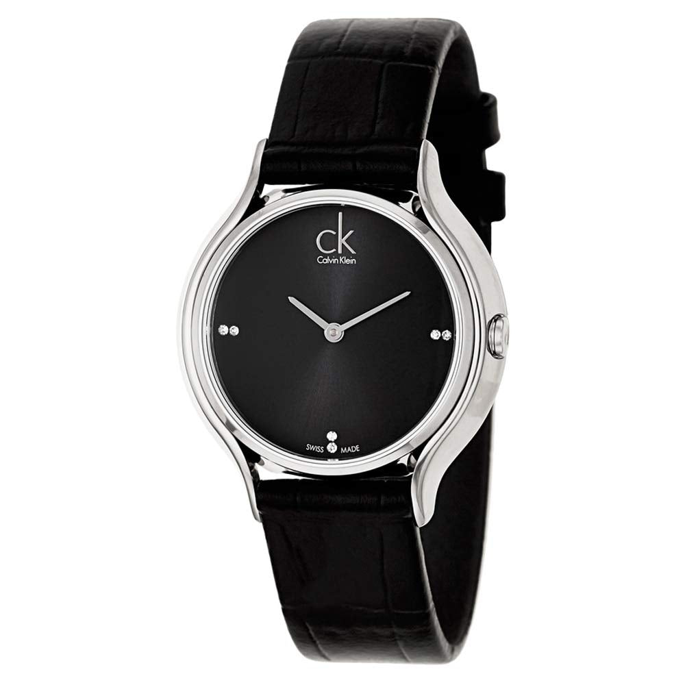 Calvin Klein Skirt watch on wrist, showing silver case, black dial, and crocodile-embossed leather strap