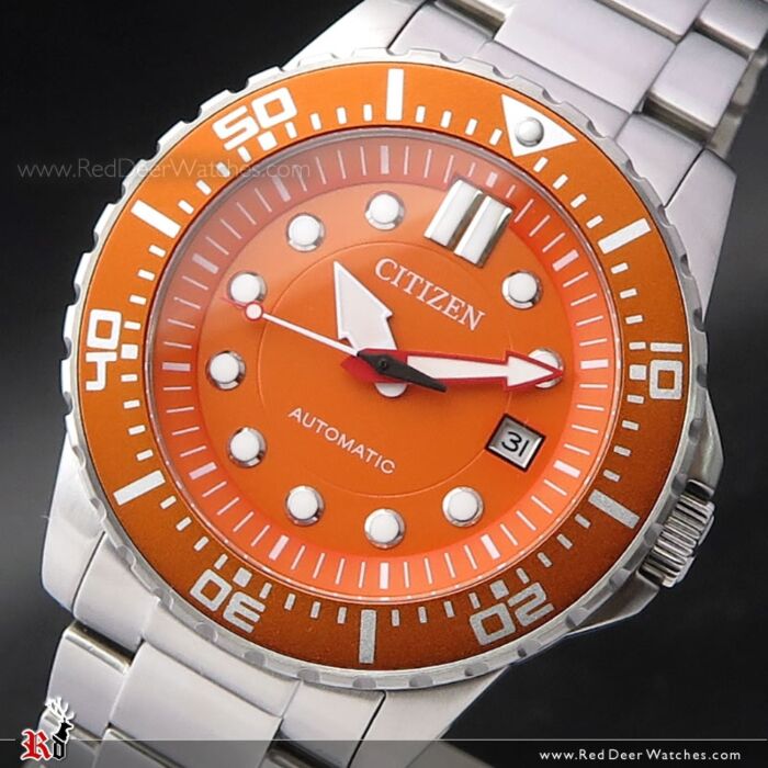 Close-up of orange dial with hour markers, automatic movement text, and date window