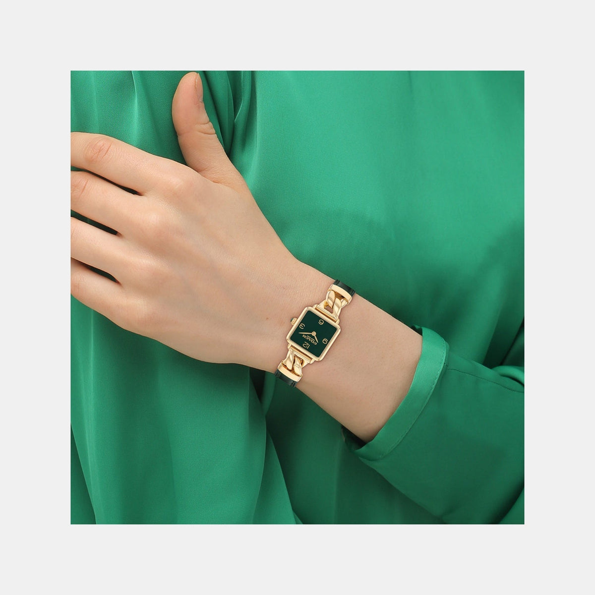 Coach Cass watch worn on wrist with gold-tone case and green leather strap