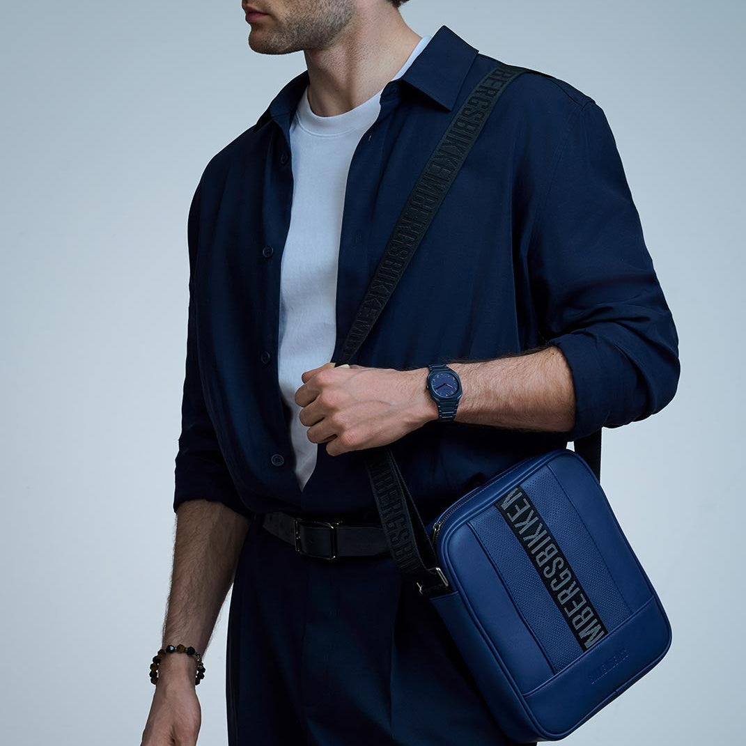 Man wearing D1 Milano Square Galaxy Blue watch with navy jacket and blue bag