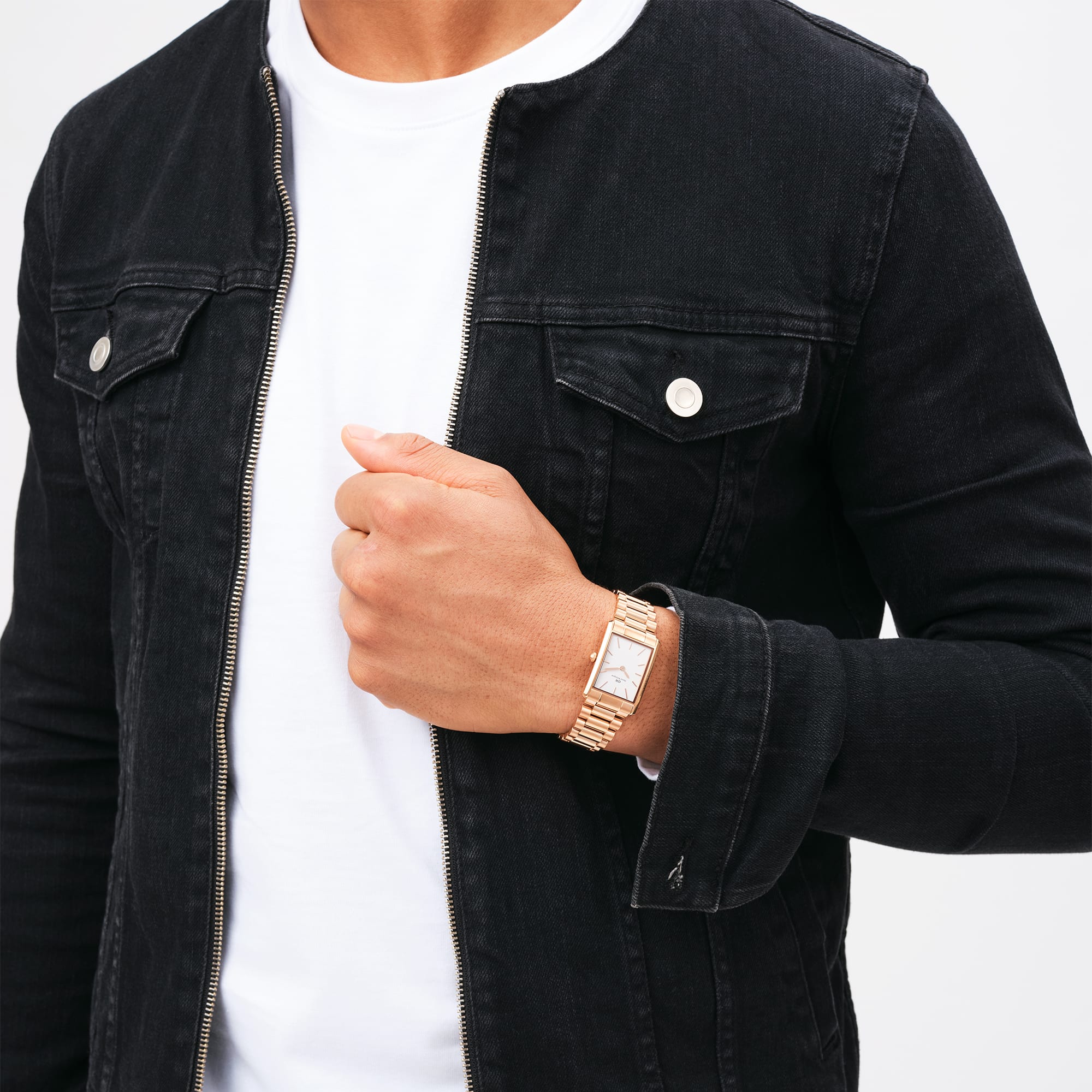 Man wearing Daniel Wellington Bound rose gold watch with black denim jacket
