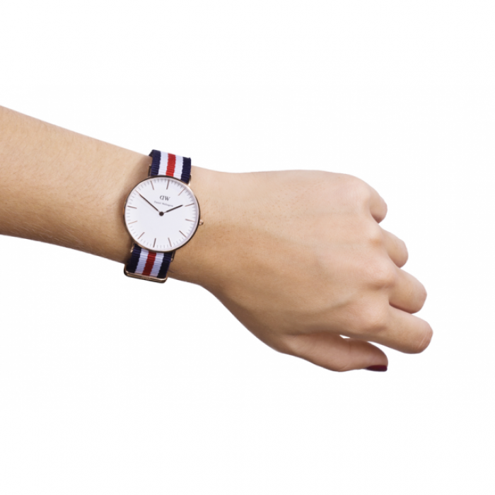 Daniel Wellington Canterbury 36mm gold watch worn on wrist with navy/red/white striped NATO strap