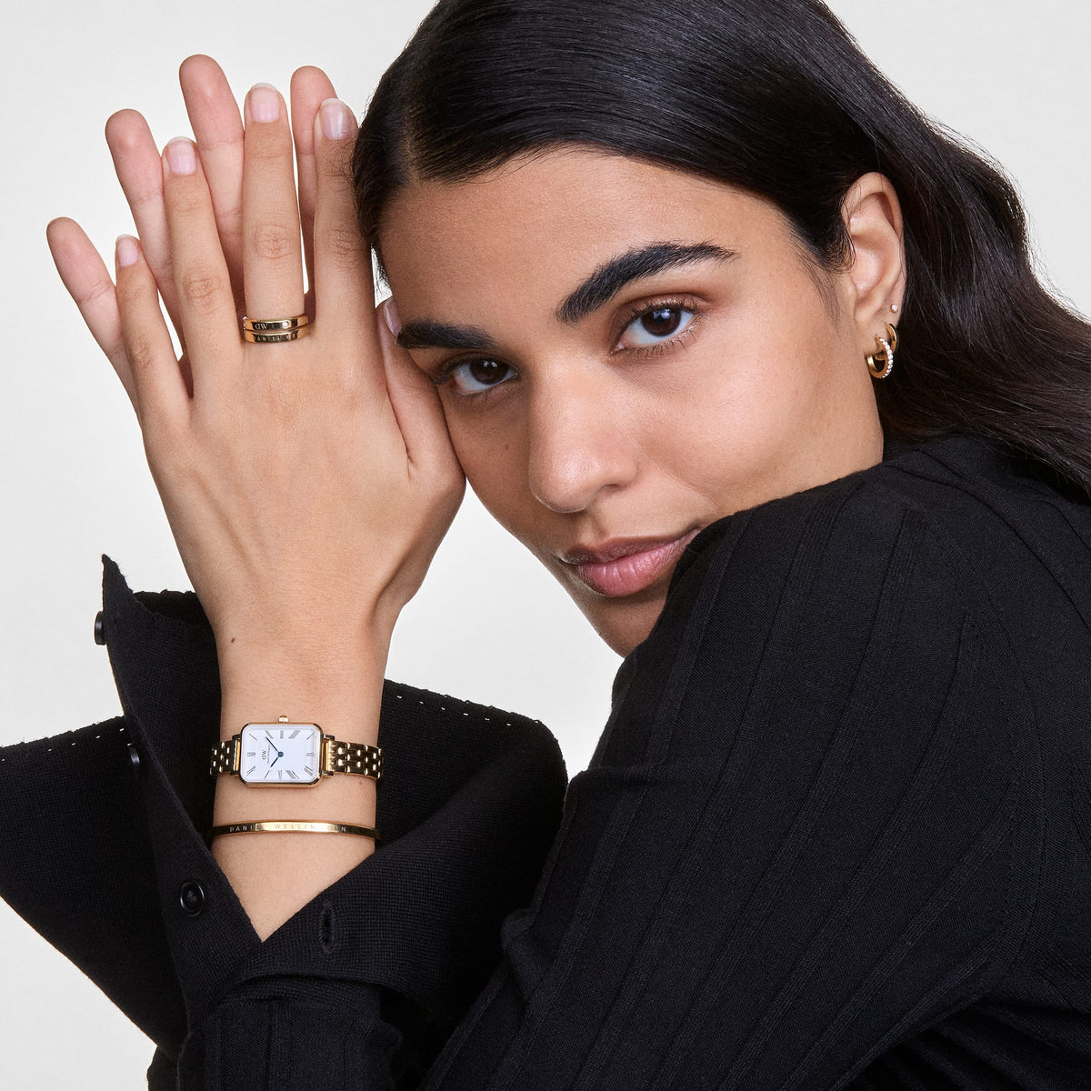 Gold and cream bangle bracelet worn on wrist with Daniel Wellington watch