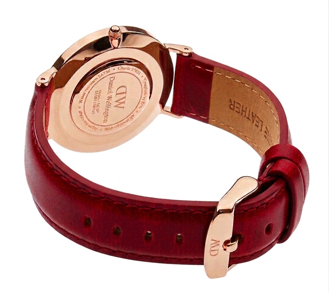 Rose gold caseback of Daniel Wellington Dapper watch with brown leather strap and buckle closure