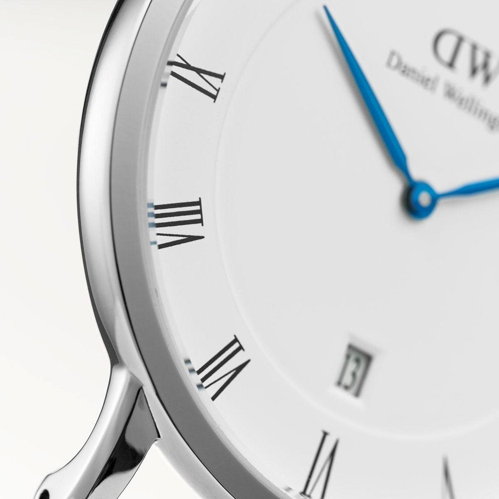 Close-up of white dial with Roman numerals, blue hands and date window on Dapper Reading watch