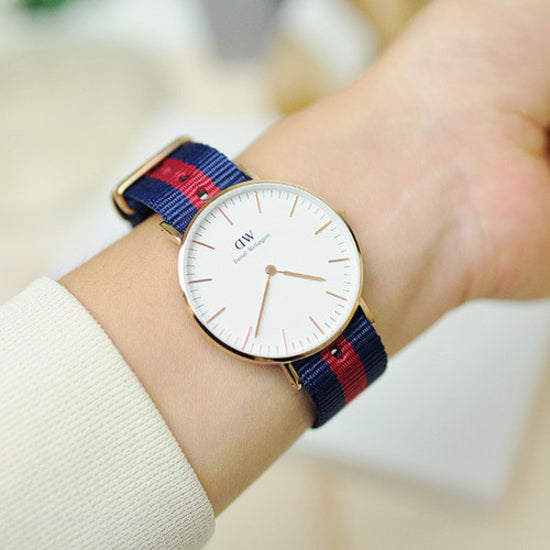 Oxford 36mm gold watch on wrist displaying minimalist white dial and striped strap