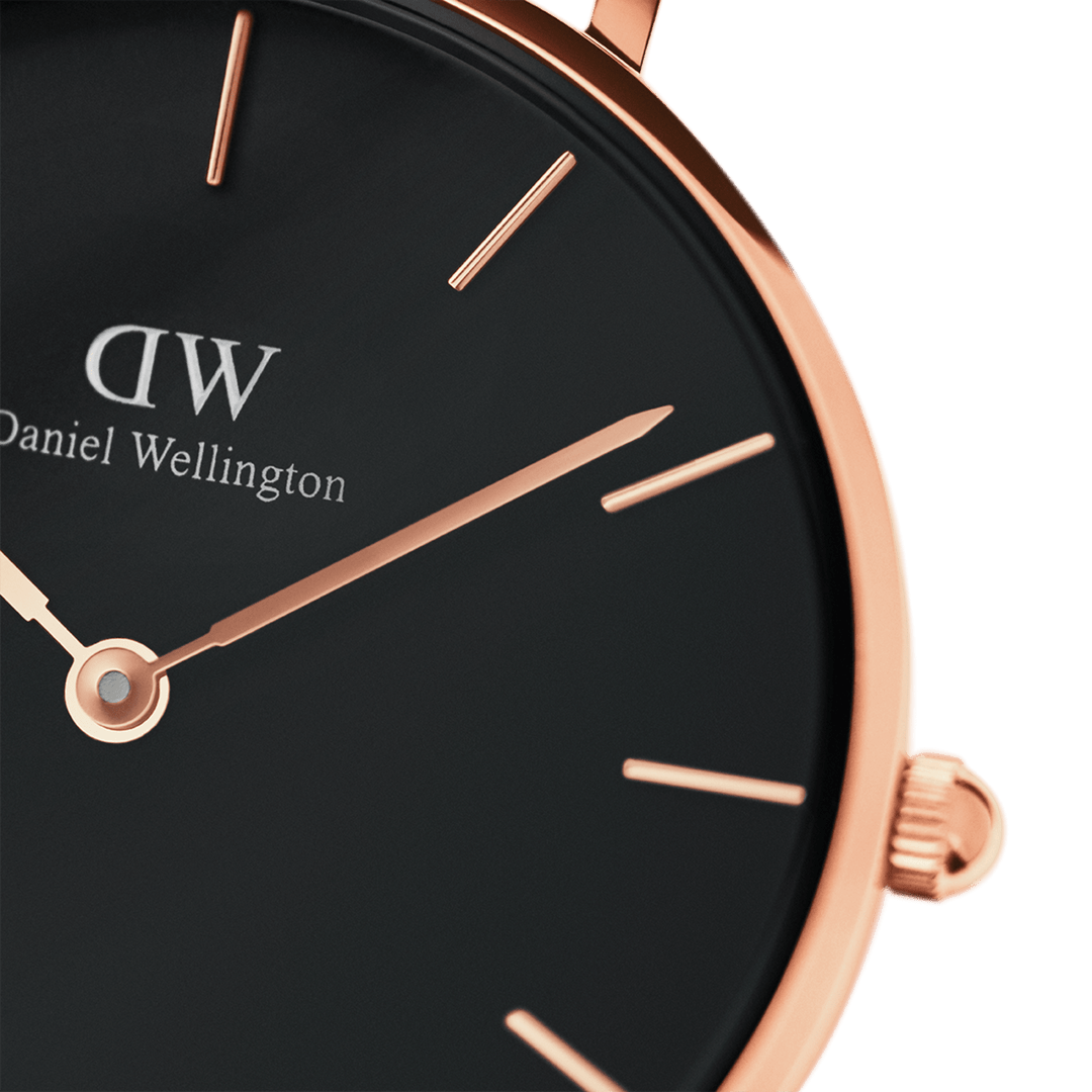 Close-up of black dial with rose gold indexes and hands, DW logo visible
