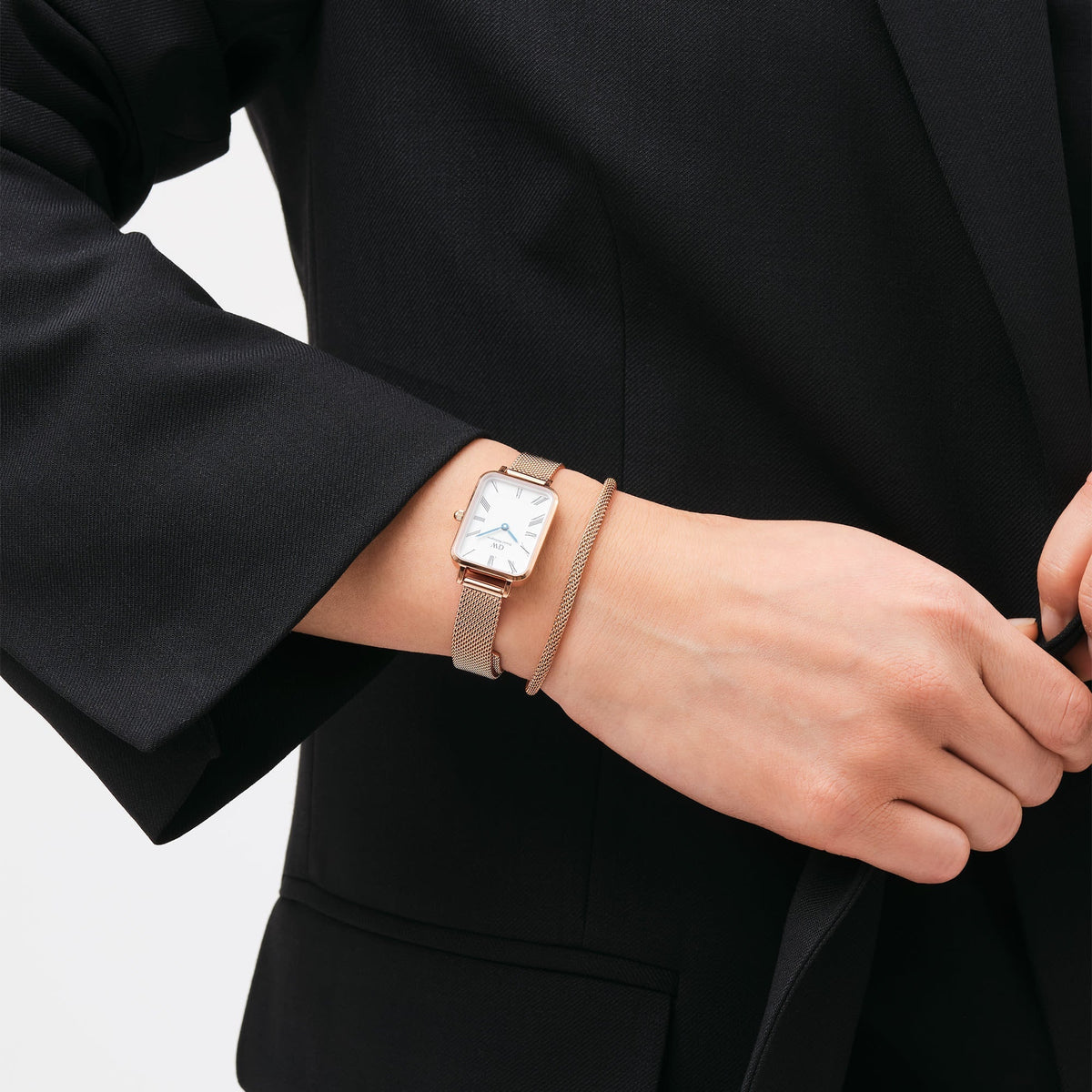 Daniel Wellington Quadro Roman Numerals women's watch worn on wrist with rose gold mesh strap