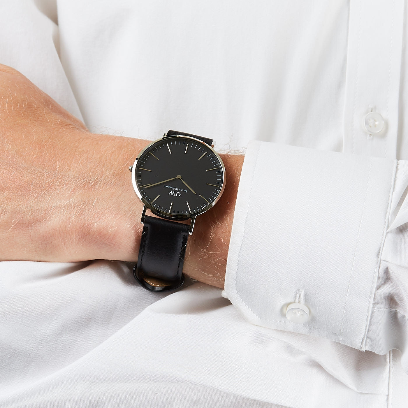 Daniel Wellington Sheffield 40mm watch worn on wrist, black dial with silver case on white shirt