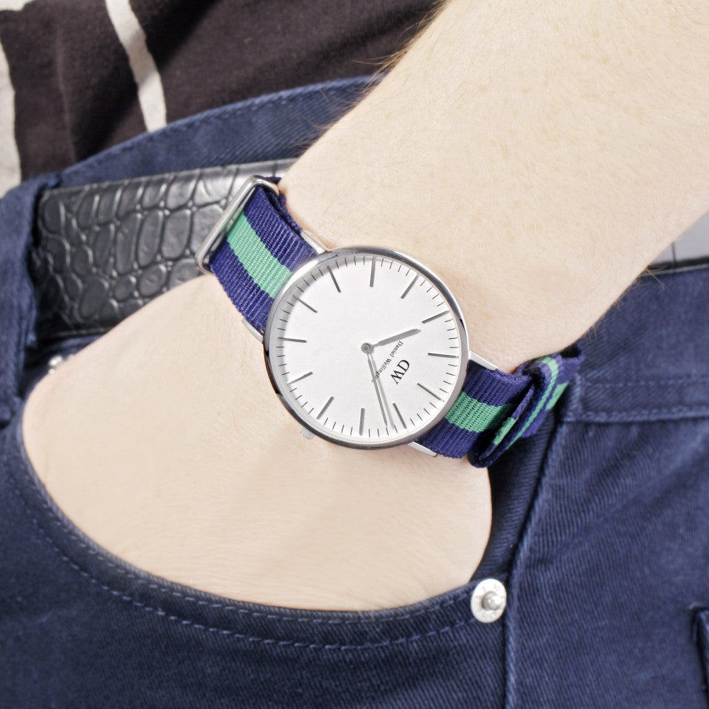 Daniel Wellington Warwick 40mm watch worn on wrist, displaying white dial and navy green striped strap