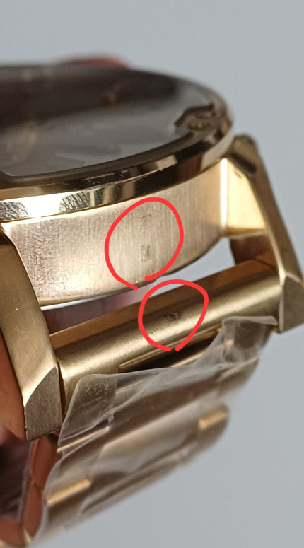 Close-up detail of gold watch case defect areas circled in red showing manufacturing imperfection