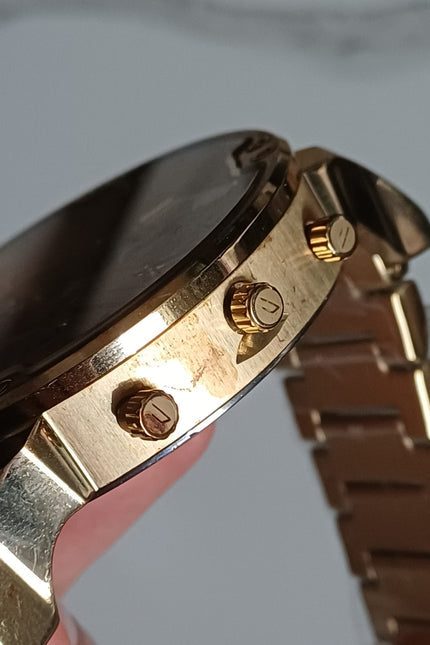 All gold chronograph watch side view showing case thickness, crown, and push button details