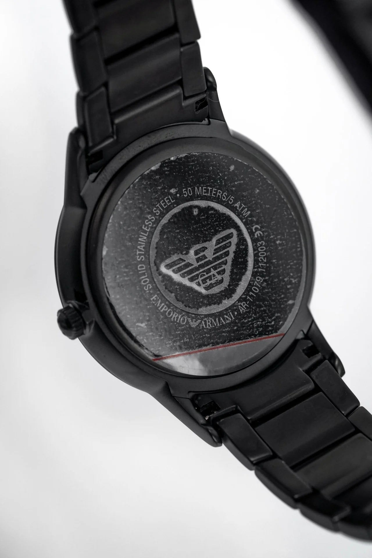 AR11079 caseback showing Emporio Armani eagle logo and engraved text