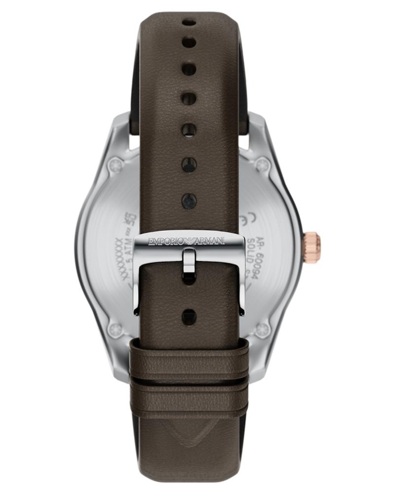 Caseback view displaying transparent crystal and buckle closure with brown leather strap