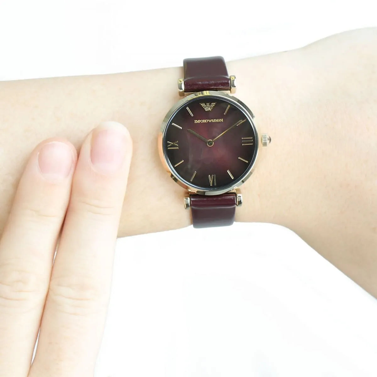 Emporio Armani Gianni AR1757 women's watch worn on wrist showing burgundy strap and dial
