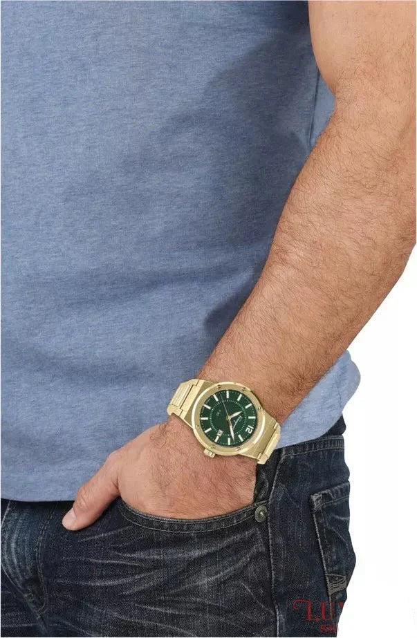 Gold watch with green dial worn on wrist, showing 44mm case size on man