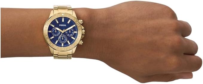 Fossil Bannon gold-tone chronograph watch worn on wrist with blue dial and stainless steel bracelet