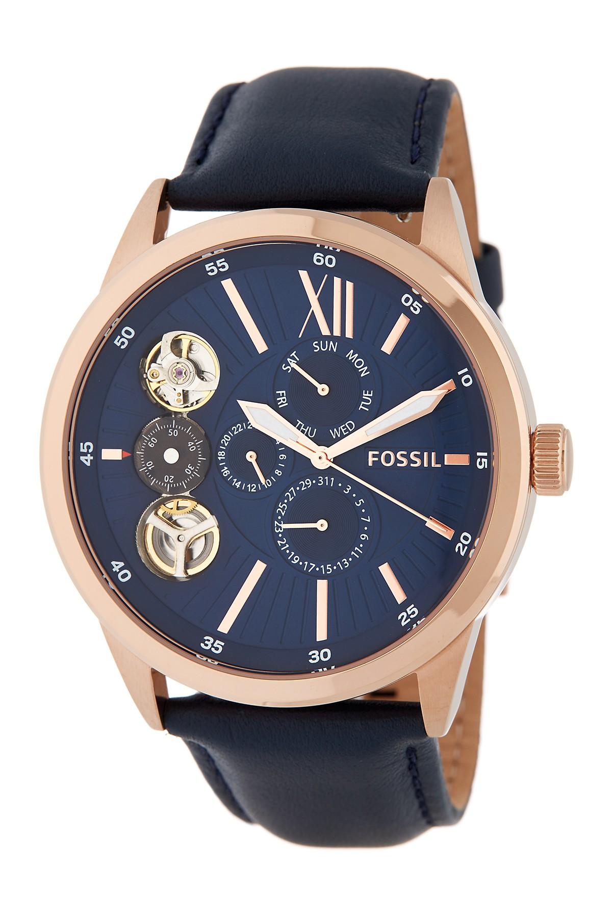 Fossil Flynn watch at angle showing navy dial with Roman numerals, skeleton windows, and rose gold case