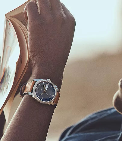 Fossil Machine FS5920 watch on wrist in outdoor lifestyle setting with tan leather strap