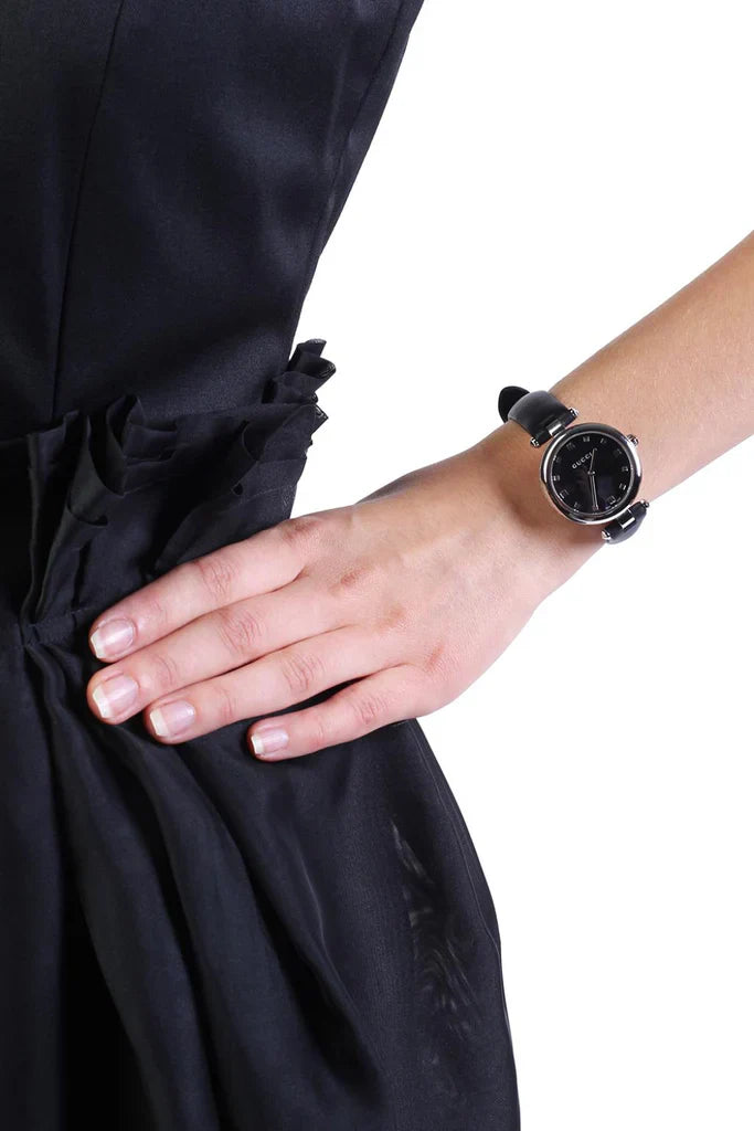 Gucci Diamantissima watch worn on wrist, displaying black dial and black leather strap