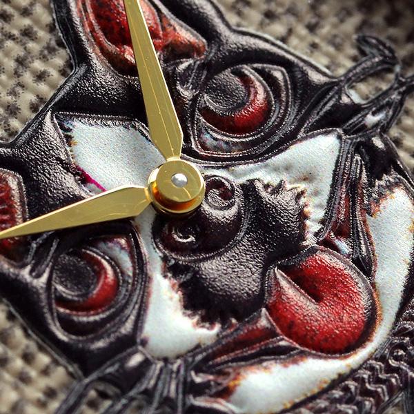 Close-up of G-Timeless cat face dial with red eyes and gold hands