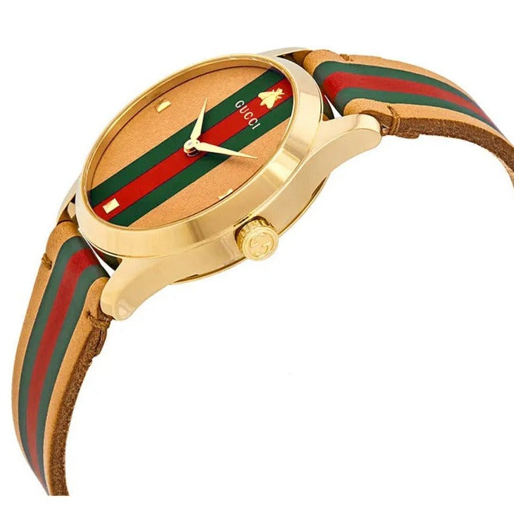 Angled view of Gucci G-Timeless 38mm watch showing gold case and striped band