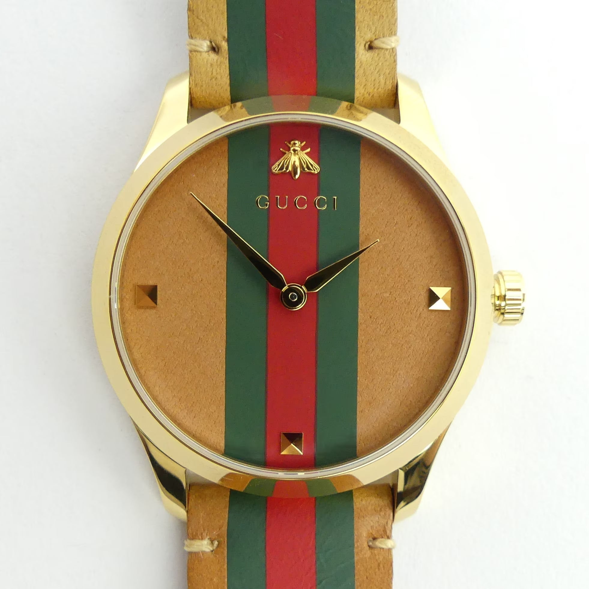 Close-up of Gucci G-Timeless dial with bee logo, green-red-green vertical stripes