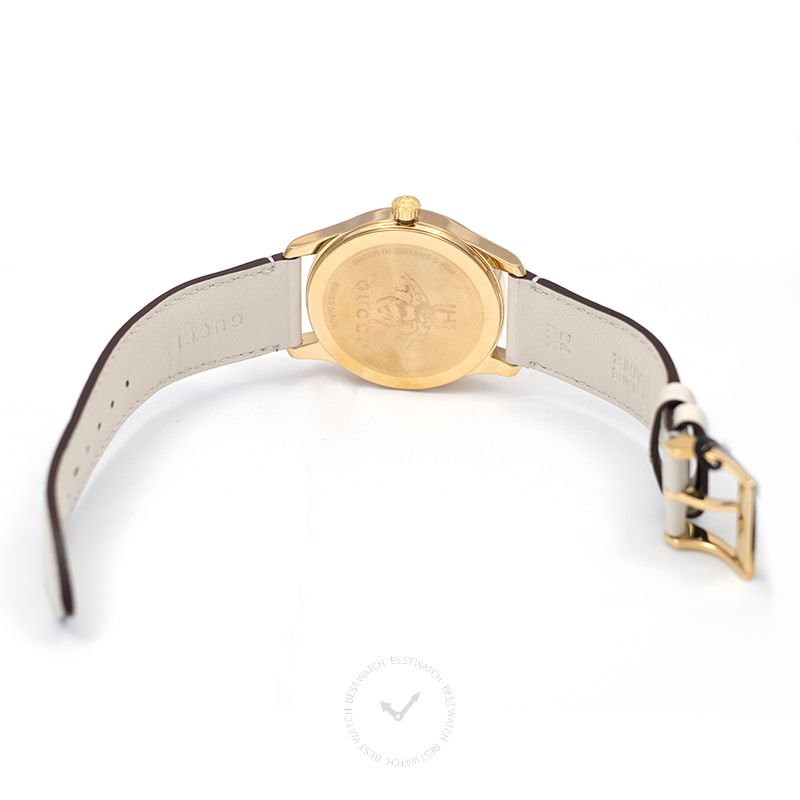 Gucci G-Timeless watch caseback showing gold-tone case and cream leather strap with buckle closure