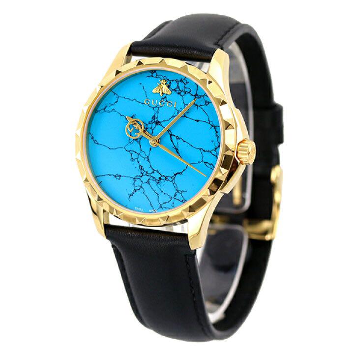 Gucci G-Timeless watch angled view showing turquoise dial with gold bee logo and studs