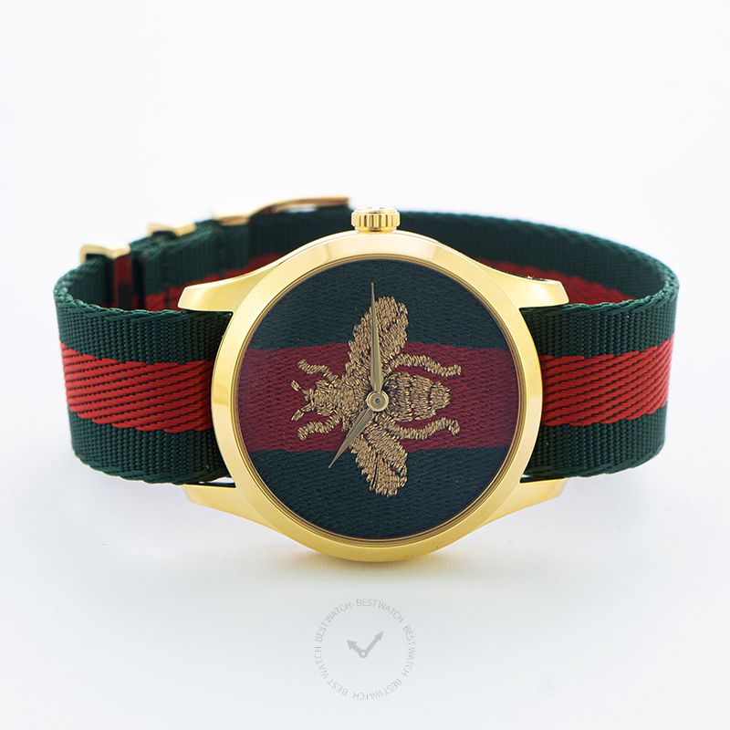 G-Timeless watch displayed at angle showing gold case and green-red striped nylon strap