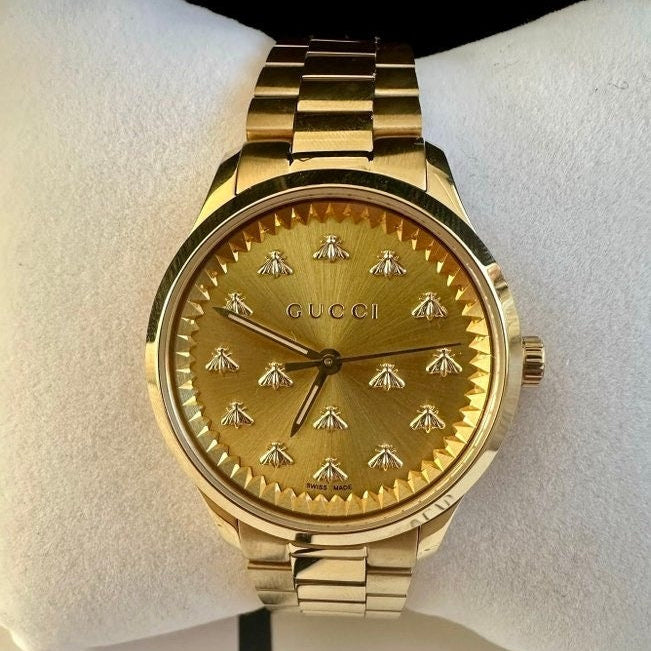 Gucci G-Timeless champagne dial close-up with bee motif and applied indices