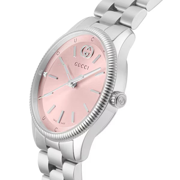 GUCCI G-Timeless watch angled view showing pink dial, beaded bezel, and stainless steel bracelet