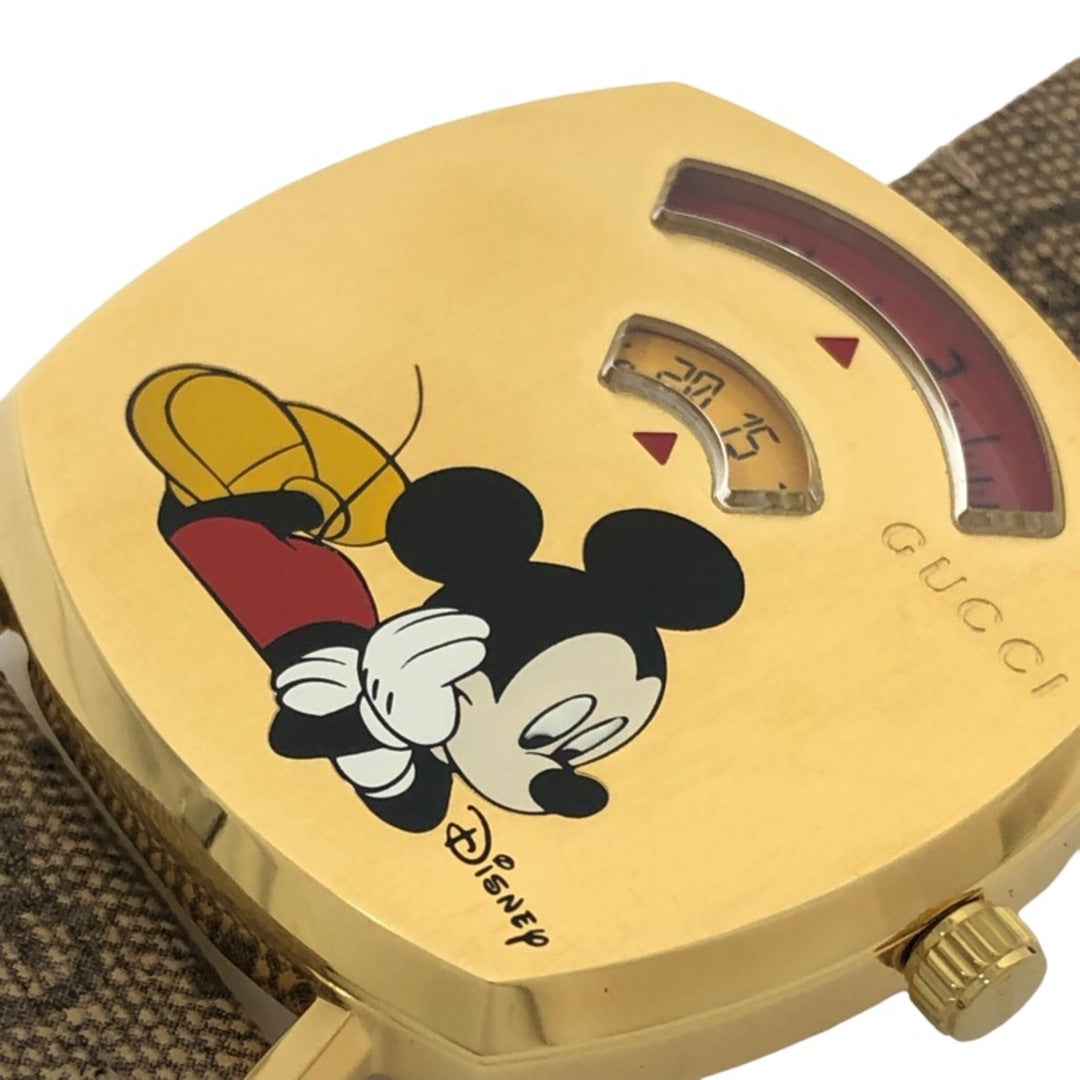 Close-up of gold dial with Mickey Mouse and Minnie Mouse illustration, Gucci branding, and red power reserve arc