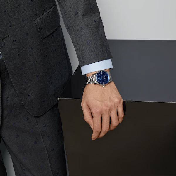 Gucci G-Timeless watch worn on wrist with blue dial and stainless steel case