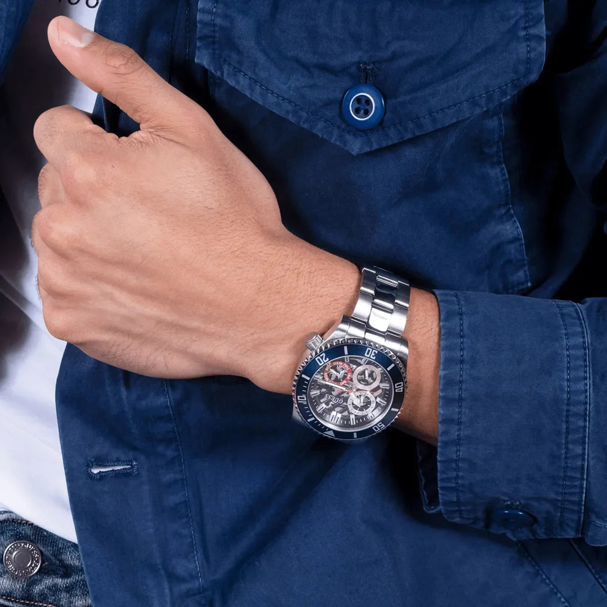 GUESS Axle men's watch worn on wrist with denim shirt