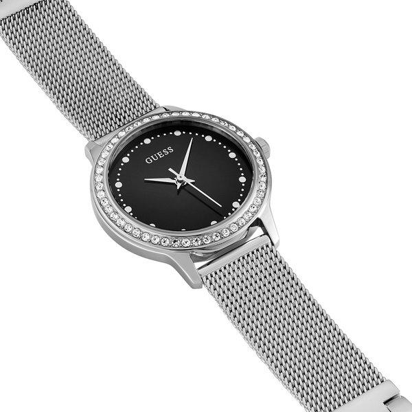 Guess Chelsea Crystals watch on wrist displaying silver mesh bracelet and black dial face