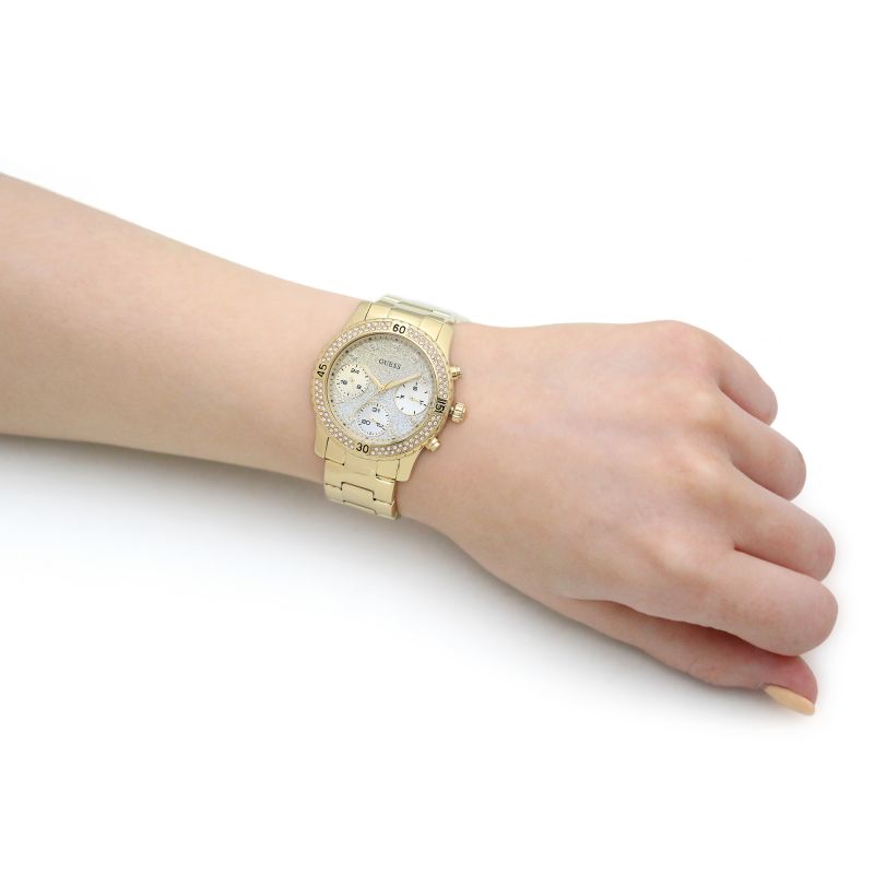Guess Confetti Crystal watch worn on wrist showing crystal bezel, glitter dial, and gold-tone bracelet fit