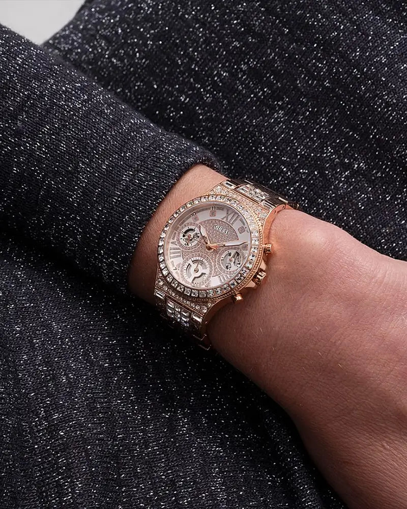 Guess Glitz rose gold chronograph watch on wrist with crystal bezel detail
