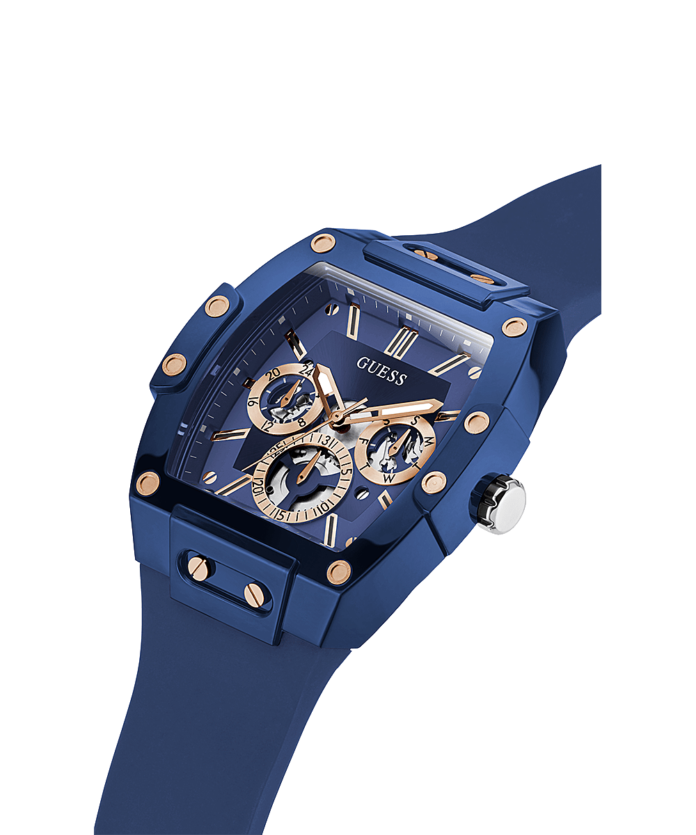 Guess skeleton watch at angle showing blue tonneau case with rose-gold skeleton dial and blue strap