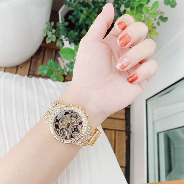 Guess GW0320L5 gold chronograph watch worn on woman's wrist
