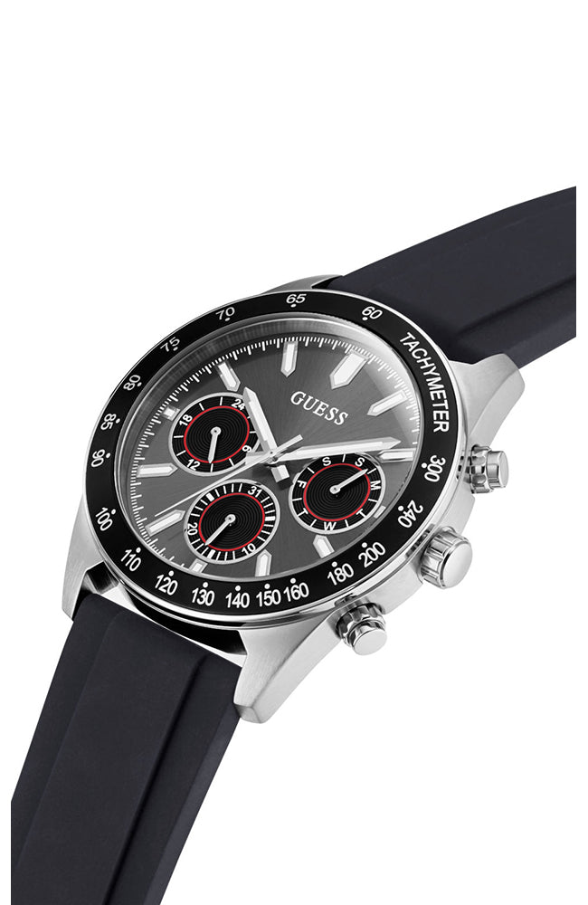 Angled view of Guess chronograph watch showing silver case, black silicone strap, and chronograph subdials