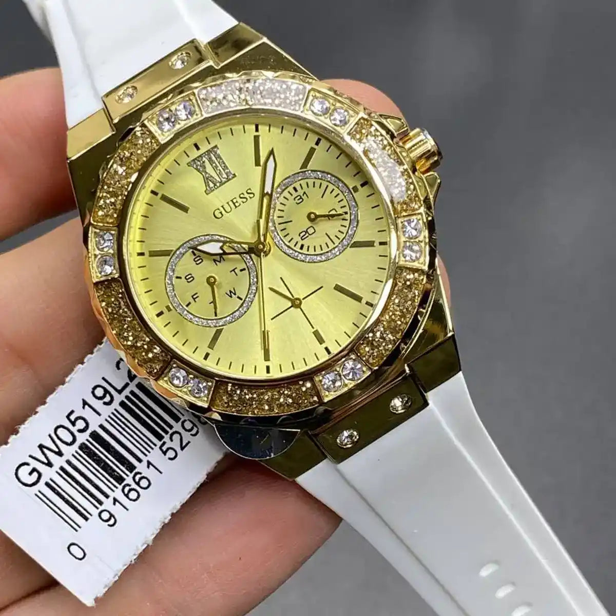 Guess GW0519L2 watch on wrist showing gold dial with chronograph subdials and crystal bezel