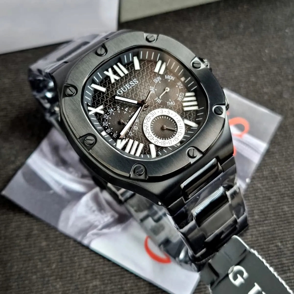 GUESS GW0572G3 black chronograph watch on box showing Roman numeral dial and three subdials