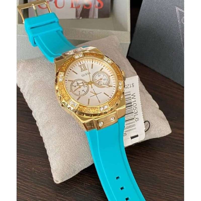 Guess Limelight watch on wrist with light blue rubber strap and Guess branded pillow display